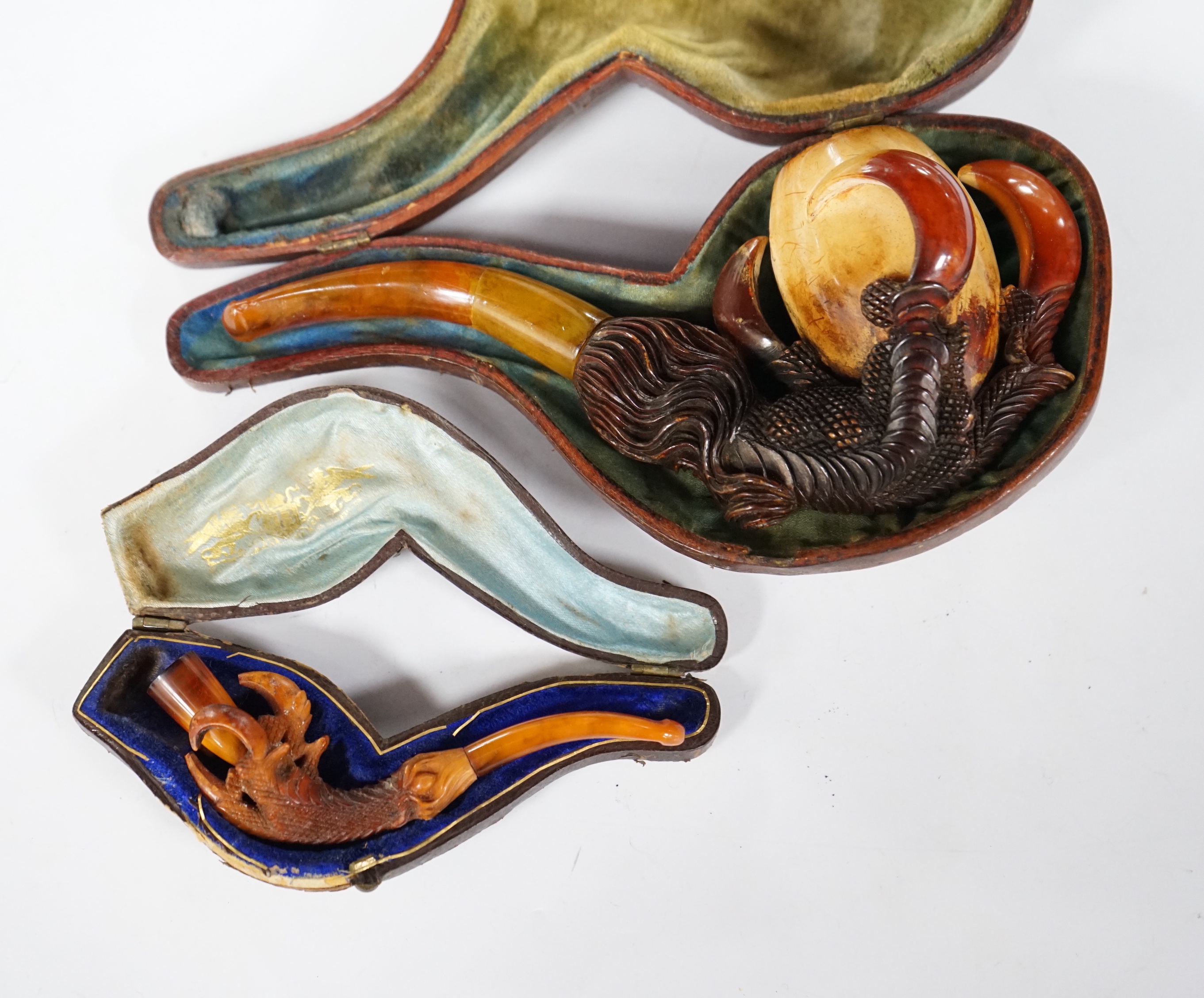 Two novelty Meerschaum pipes both with dragon claw talon pipe bowls and amber mouthpieces, largest 17cm long